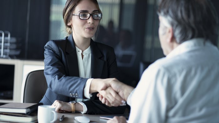 Woman shaking hands with a male client