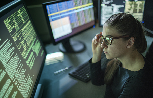 A female lawyer reads an article on how to be prepared for cyberattacks with holographic numbers in the foreground.